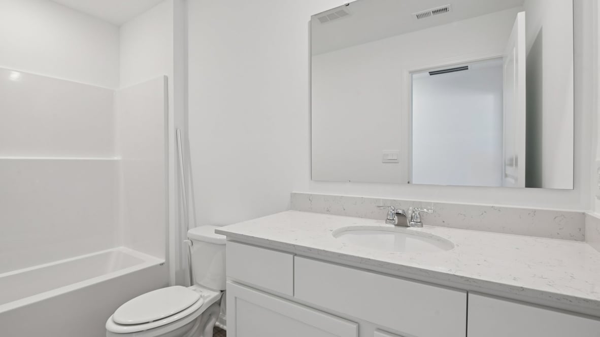 hall bathroom with white cabinets and tub shower