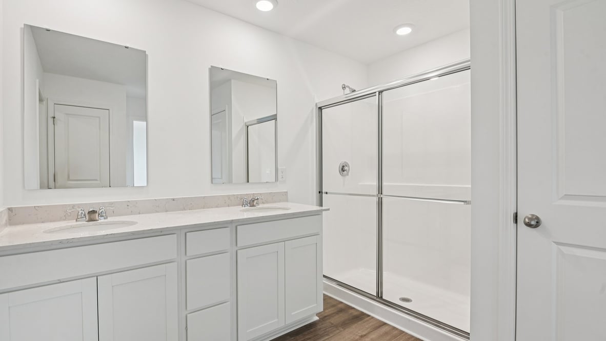 primary bathroom with dual vanity and walk-in shower