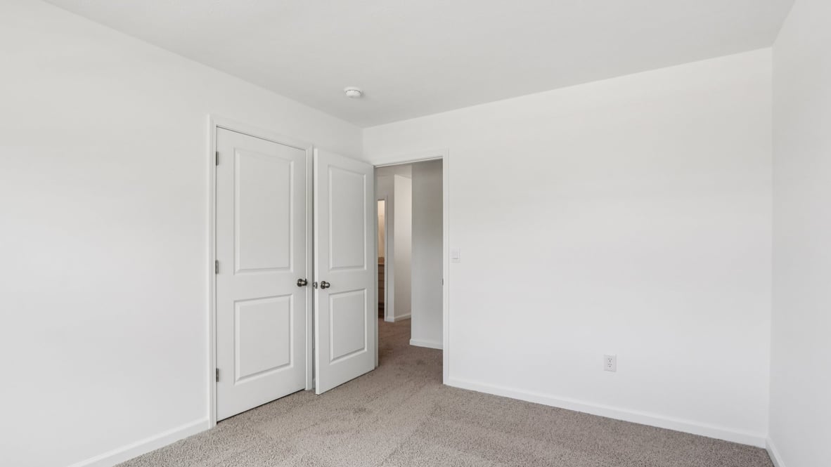 bedroom with beige carpet, white walls and a window