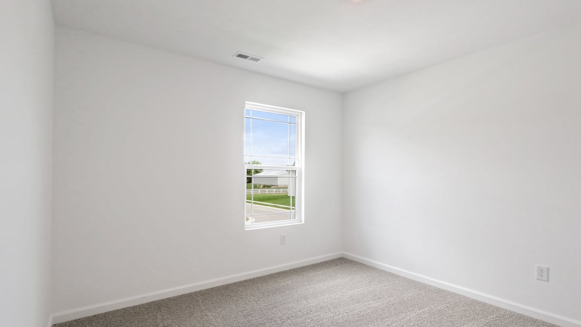 bedroom with beige carpet, white walls and a window