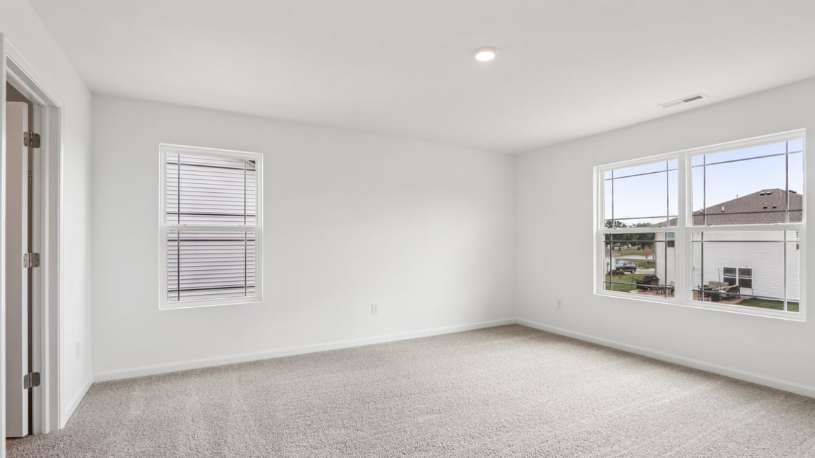 bedroom with beige carpet, white walls and a window