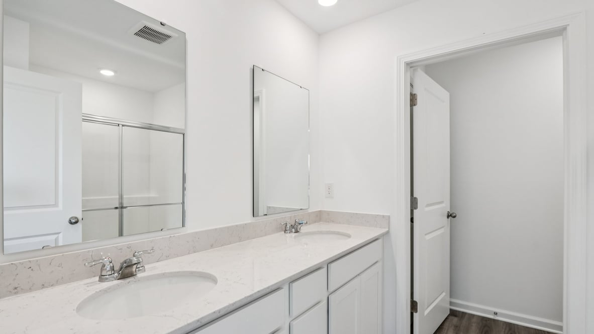 Sleek family-guest bath with single sink, mirror, cabinets, and shower-tub combination at Centre Place