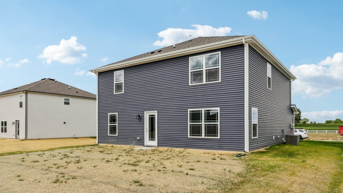Backyard with concrete patio area offering room for seating, grill setup, and a transition from indoor to outdoor living