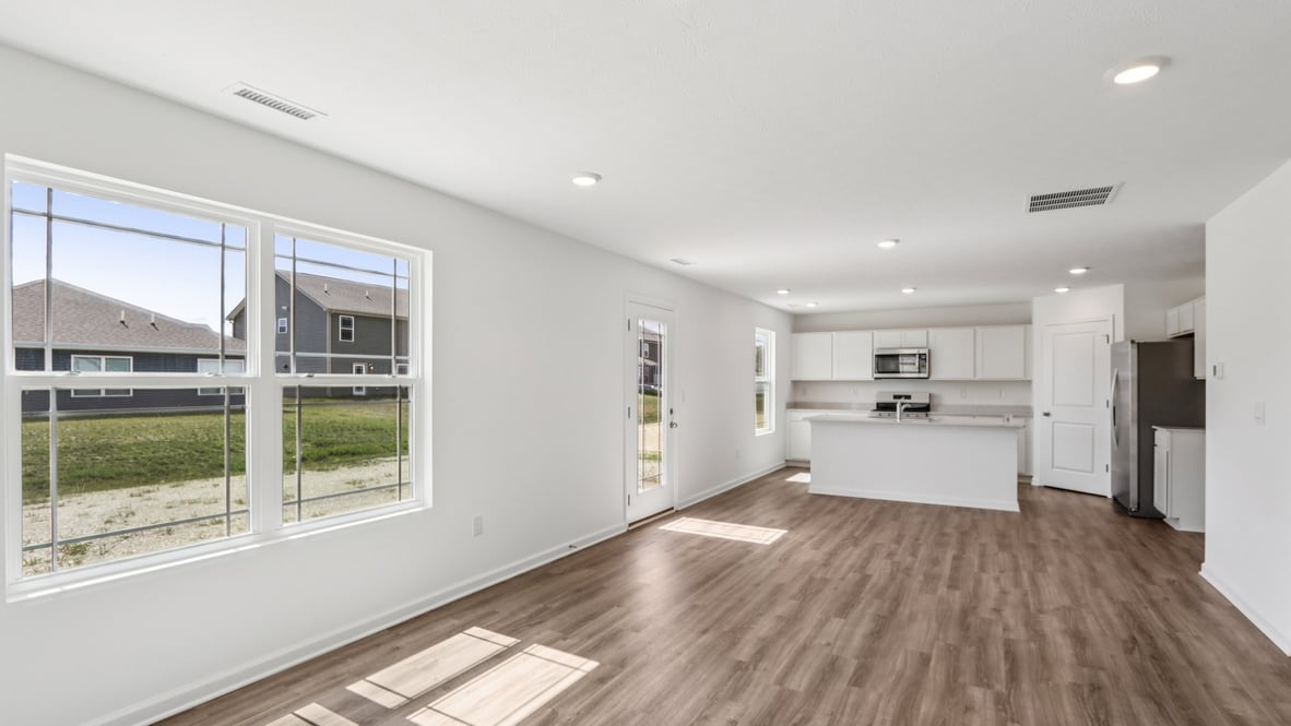 Living room looking to kitchen, dining, next to outdoor areas in this new townhome features natural light, with open concept