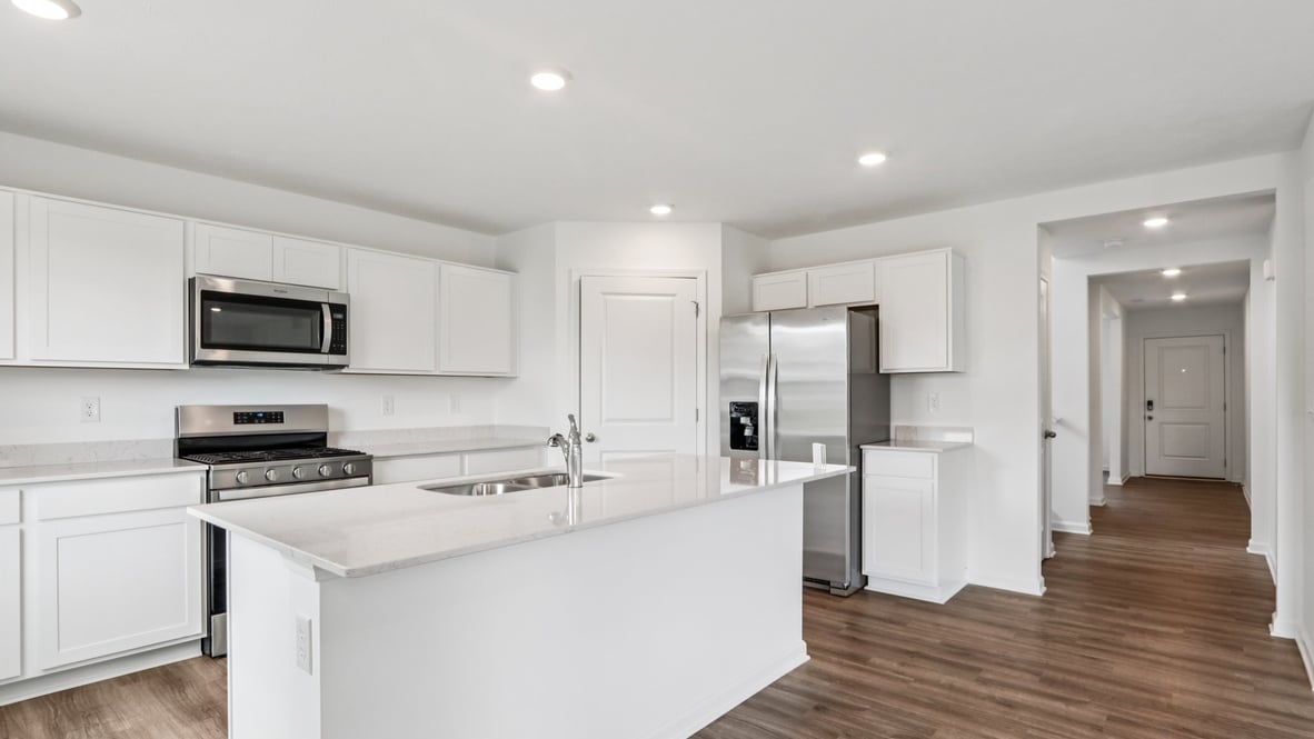 Kitchen view- entry hallway in this new home features a long corridor with access and sightlines into the open concept zones