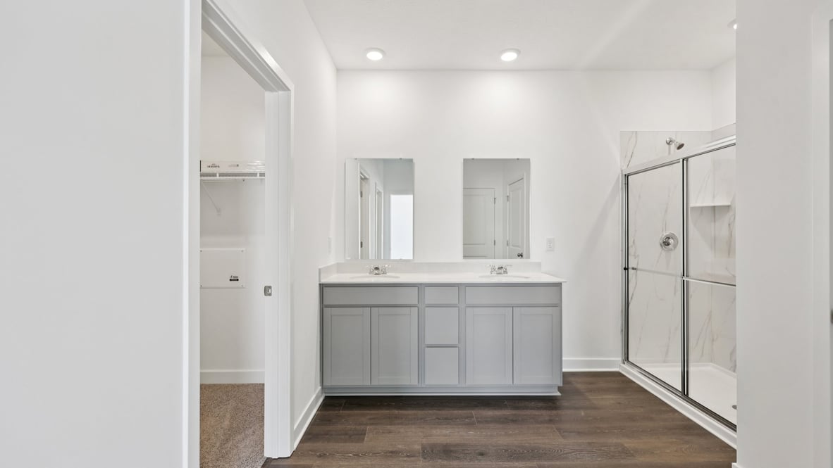 primary bedroom with dual vanity and walk-in shower