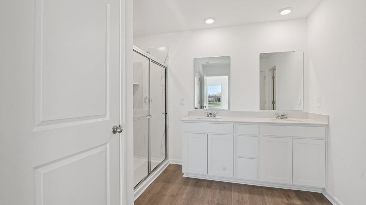 primary bathroom with dual vanity and walk-in shower