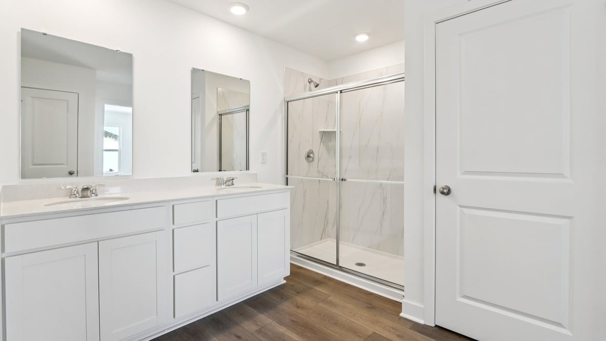 primary bathroom with dual vanity and walk-in shower