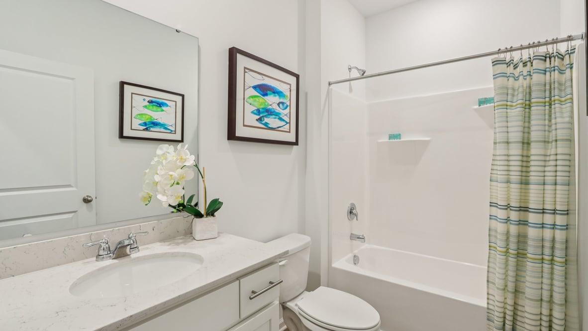 hall bathroom with white cabinets quartz countertop commode and tub shower