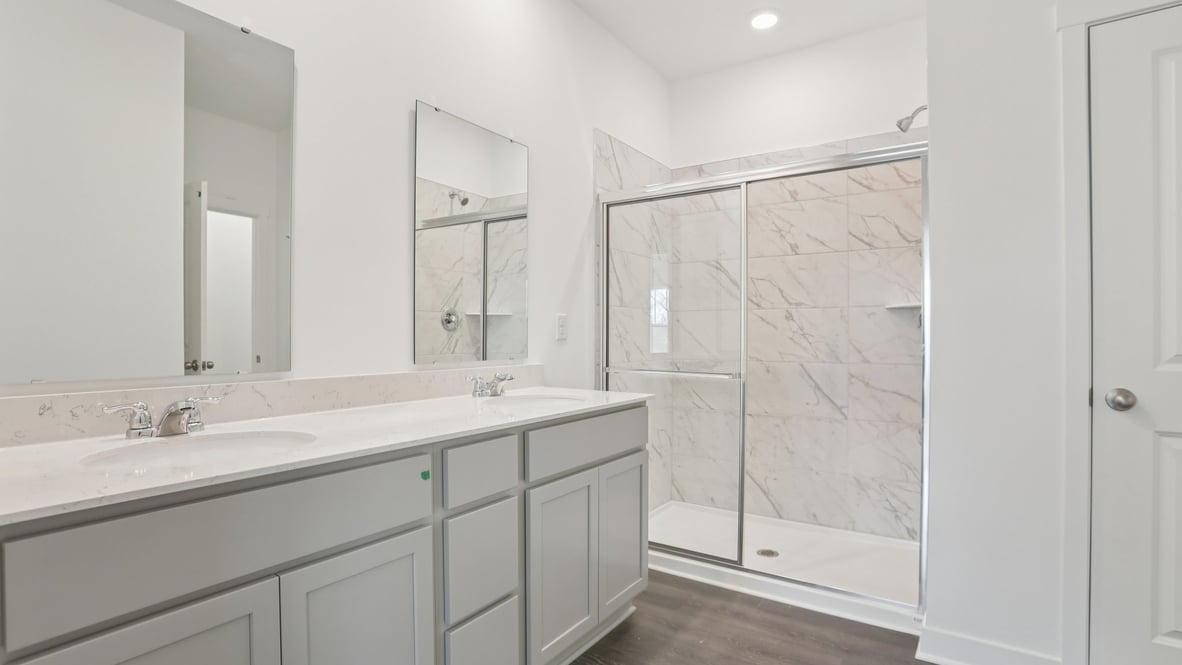 primary bathroom with dual vanity and walk-in shower