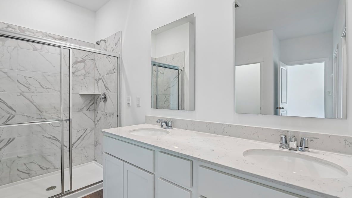 primary bathroom with dual vanity and walk in shower