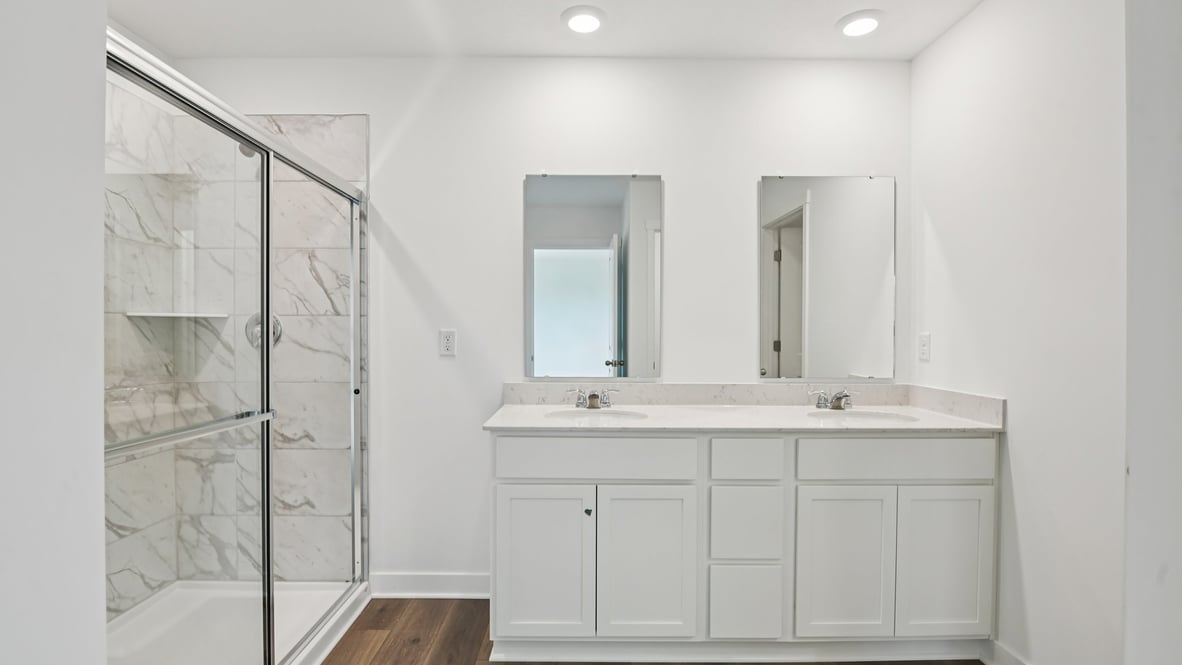 primary bathroom with dual vanity and walk-in shower