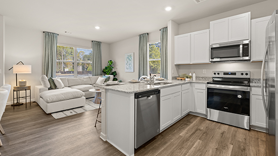 kitchen with quartz countertops, stainless steel appliances and bar seating in townhome