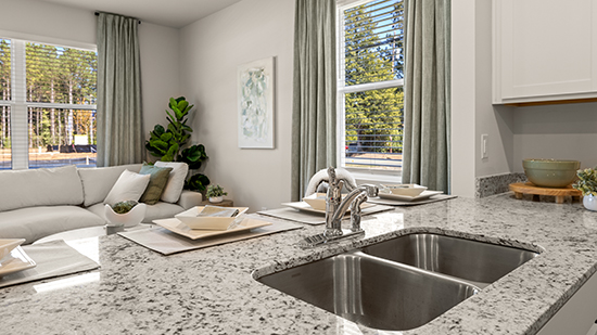 kitchen with quartz countertops, stainless steel appliances and bar seating in townhome