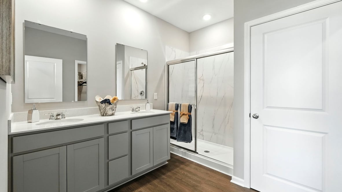 primary bathroom with double vanity and walk in shower