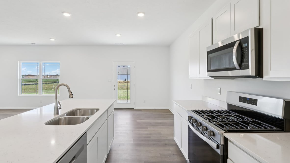 kitchen with quartz countertops and center island and bar seating and stainless steel appliances