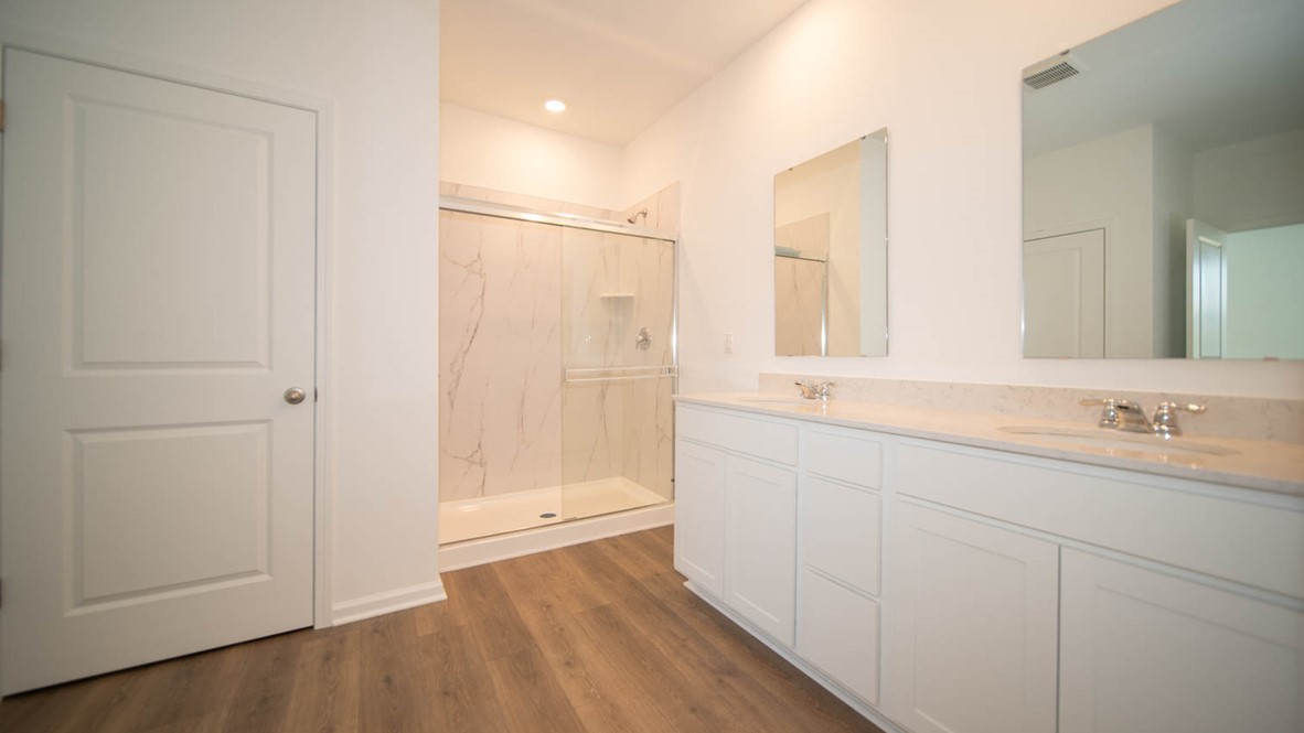 primary bathroom with dual vanity and walk-in shower