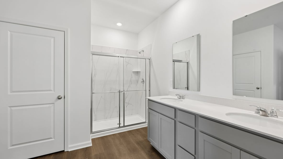 primary bathroom with dual vanity and walk-in shower
