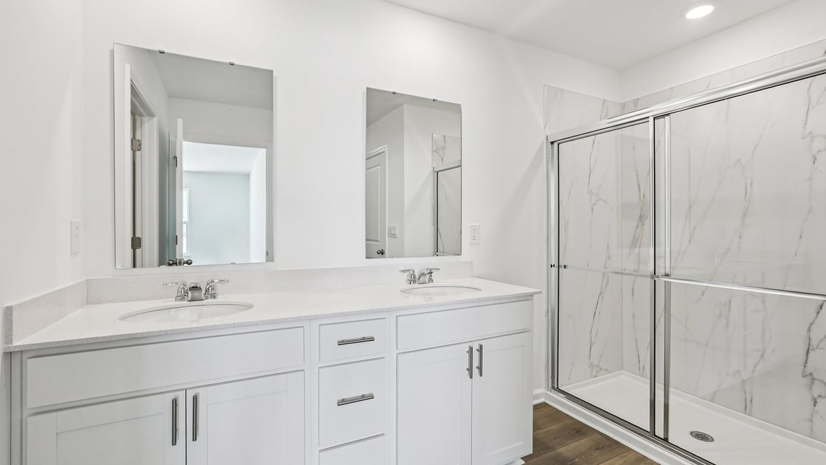 primary bathroom with dual vanity and walk-in shower