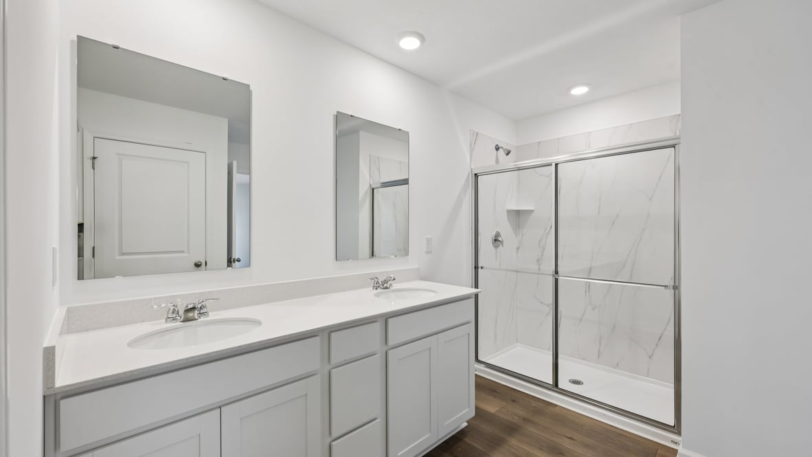 primary bathroom with dual vanity and walk-in shower