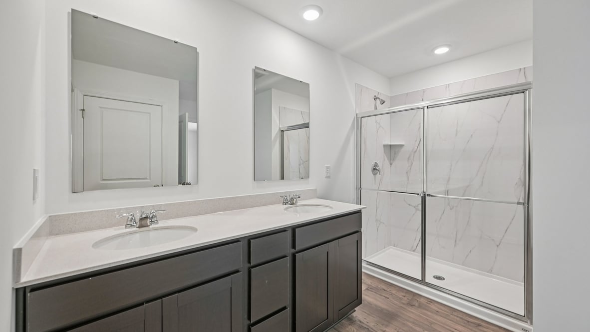 primary bathroom with dual vanity and walk-in shower