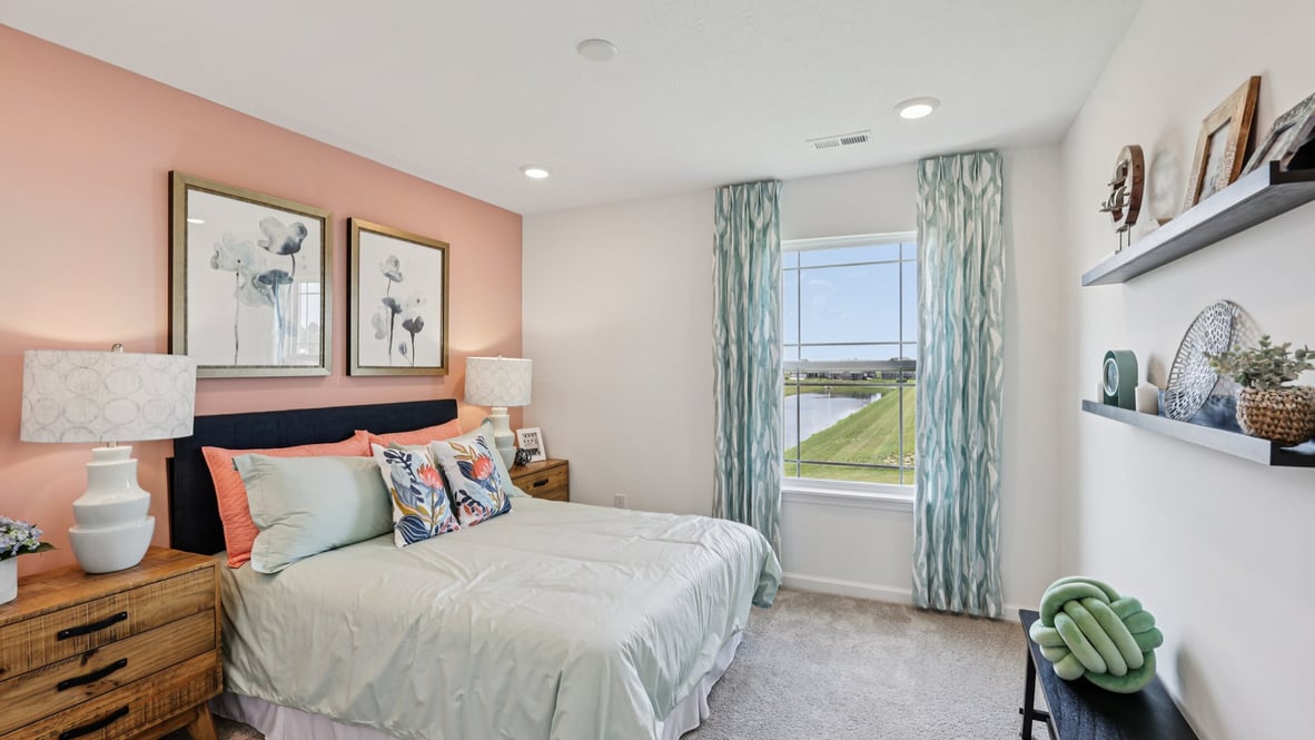 bedroom with beige carpet, a pink accent wall, and a window