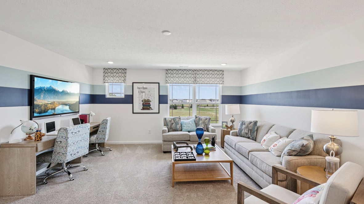 upstairs loft featuring a grey sectional and window