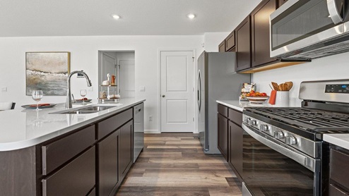 Colonial Heights Bellamy model home kitchen with draven LVP flooring and stainless steel appliances
