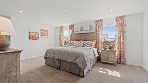 Colonial heights Bellamy model home large main bedroom with 2 windows and carpet flooring