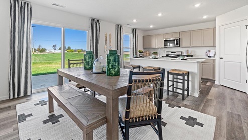 Livingston Lakes Holcombe model home open floor plan dining room with sliding glass door leading to patio and backyard