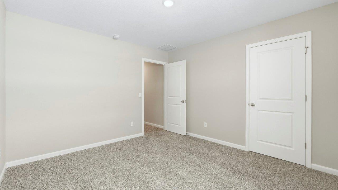bedroom 2 with elk beige carpet, popular grey walls, 1 window, and closet