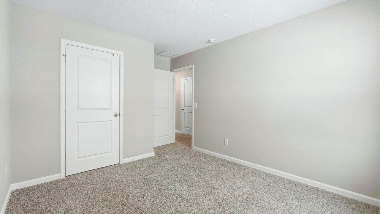 bedroom 3 with elk beige carpet, popular grey walls, 1 window, and closet