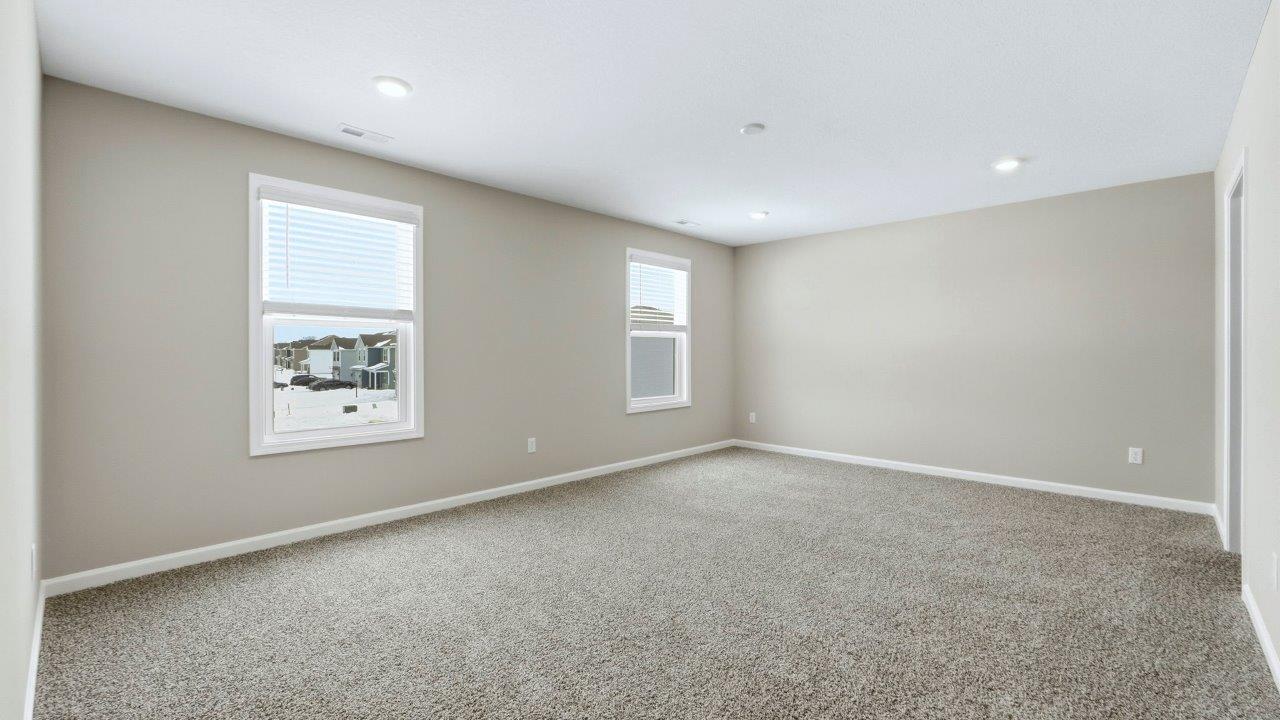 spacious primary bedroom with elk beige carpet, popular grey walls, 2 windows, disc lighting, and ensuite walk-in closet and bathroom