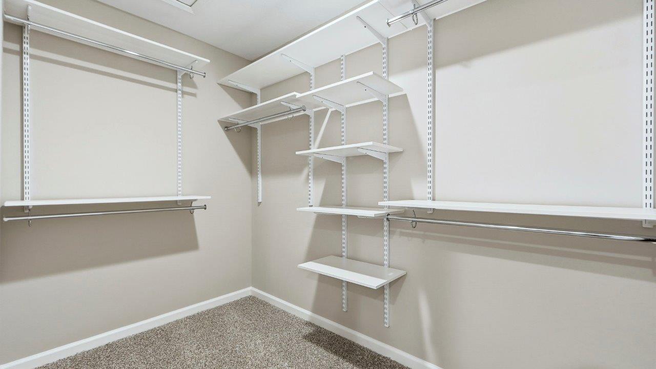 primary ensuite walk-in closet with built-in freedom rail shelving