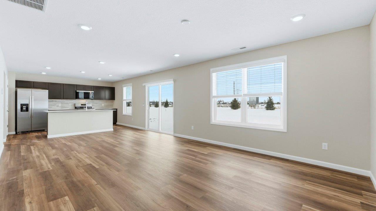 living room with mohawk eastmont lvp flooring, 2 large windows, popular grey walls, and disc lighting