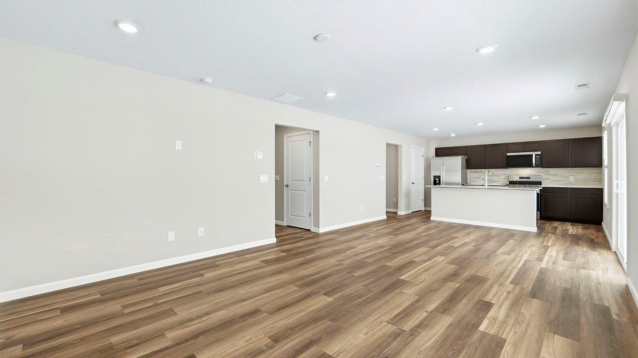 living room with mohawk eastmont lvp flooring, 2 large windows, popular grey walls, and disc lighting