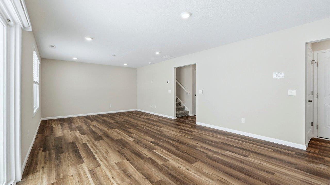 living room with mohawk eastmont lvp flooring, 2 large windows, popular grey walls, and disc lighting