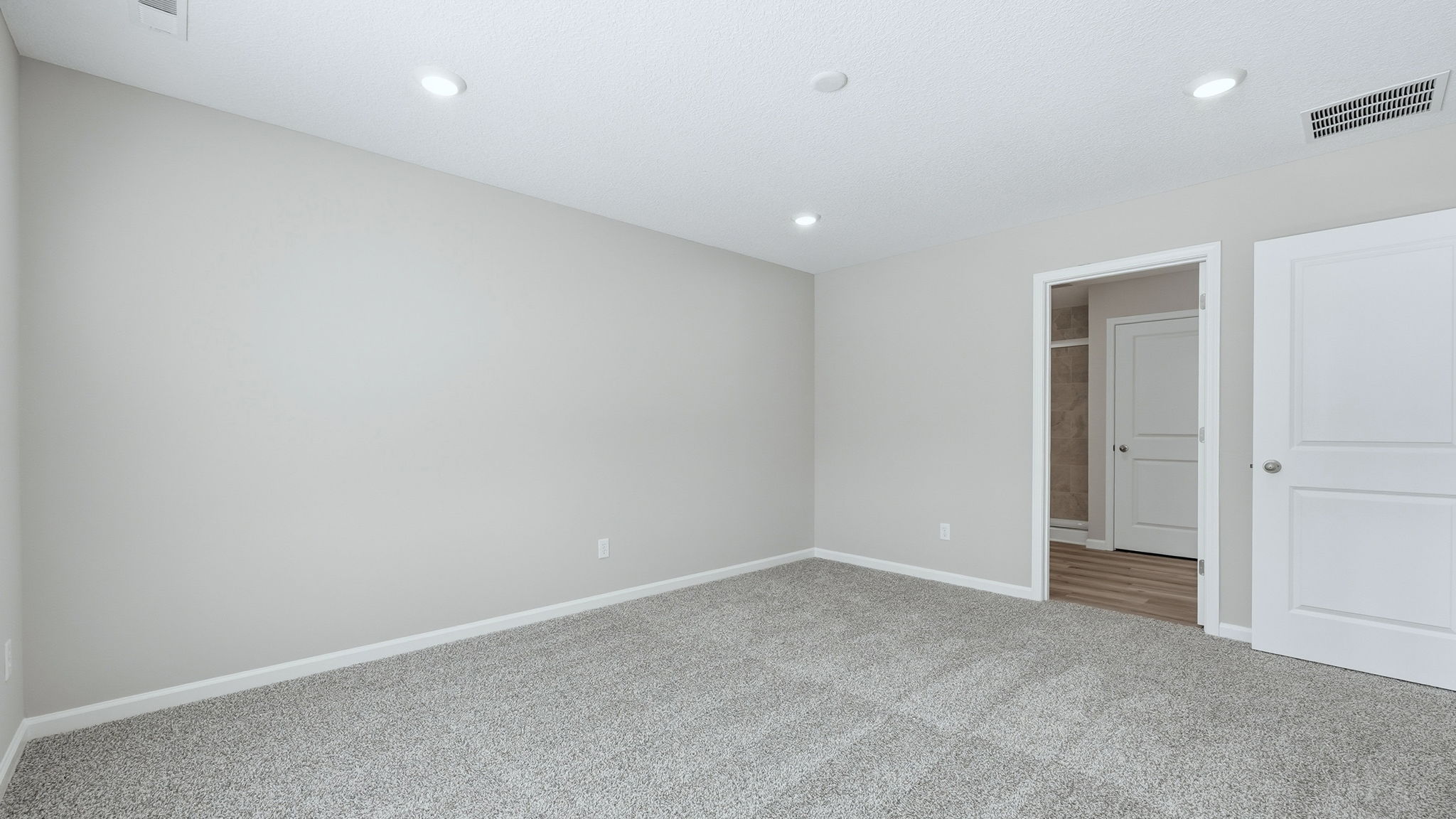 Trader's Trace Chatham primary bedroom with carpet, popular grey walls, 2 windows, and ensuite bath and walk-in closet.