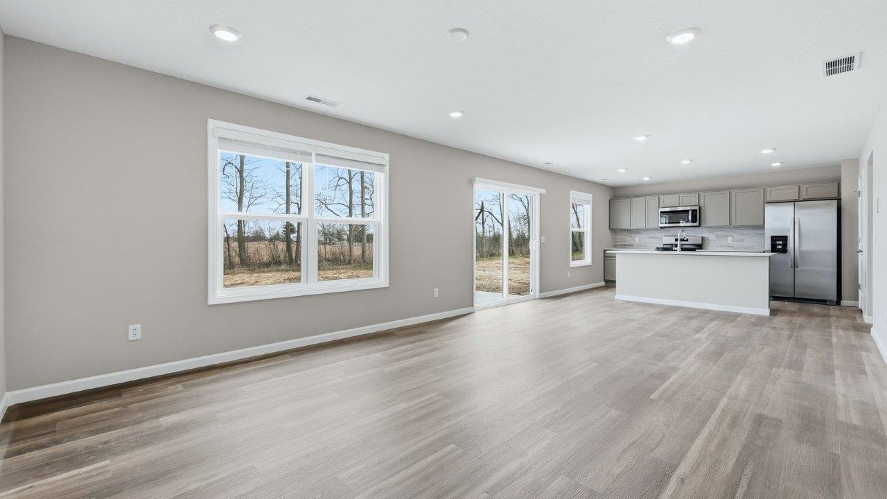 living room with mohawk eastmont lvp and popular grey walls. open concept to foyer, casual dining, and kitchen