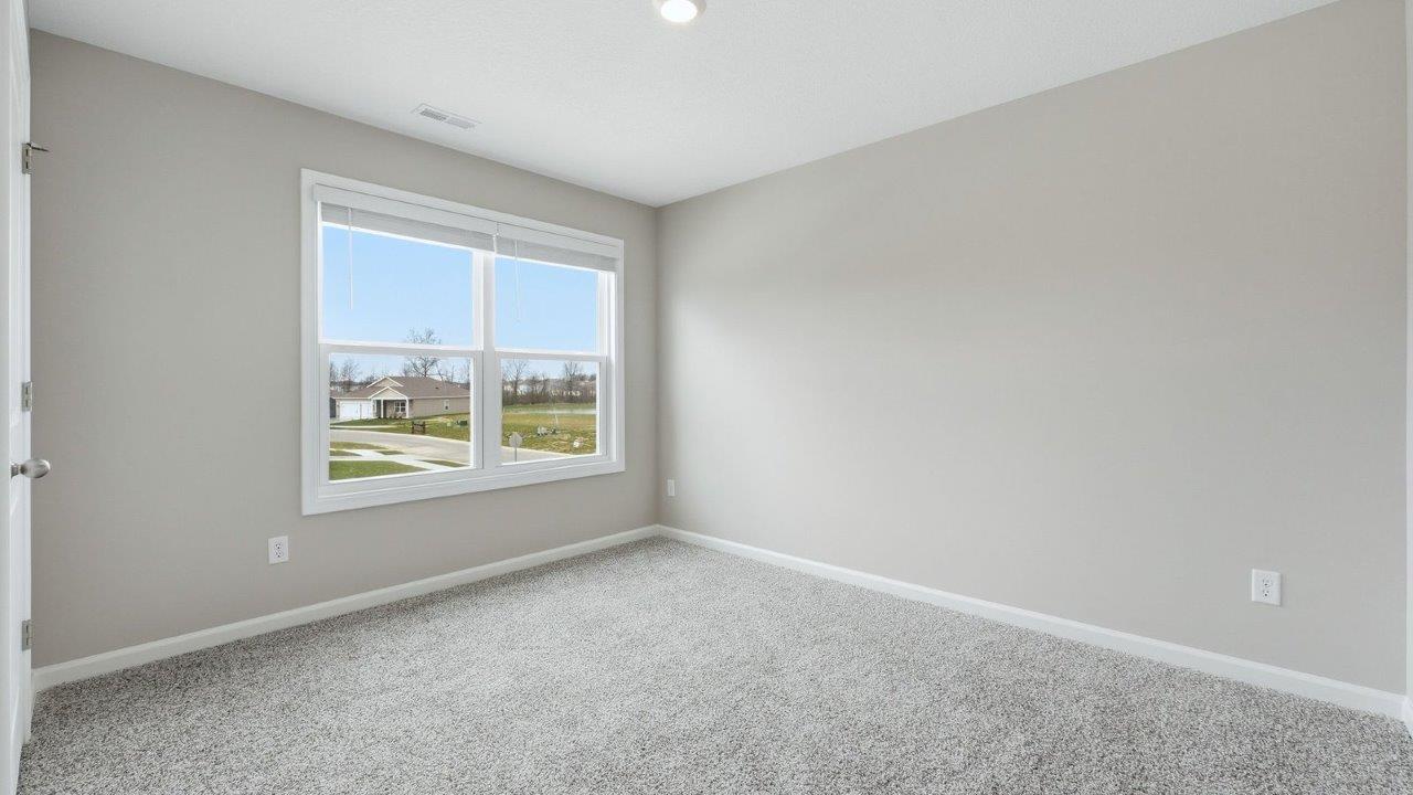 bedroom 2 with beige carpet, 2 windows, closet, and popular grey walls