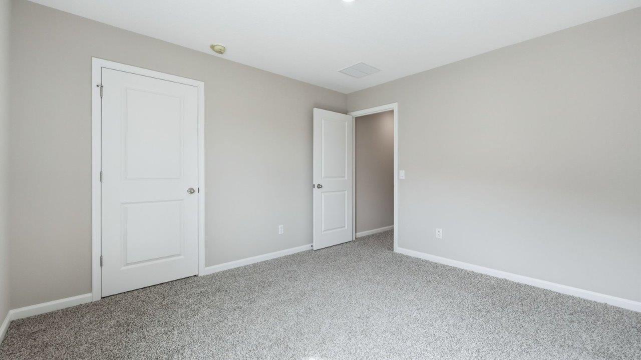 bedroom 2 with beige carpet, 2 windows, closet, and popular grey walls
