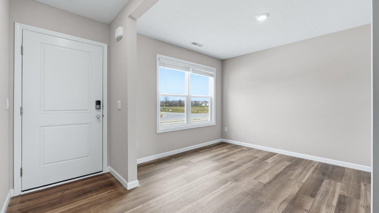 front door and foyer with mohawk eastmont lvp flooring and popular grey walls