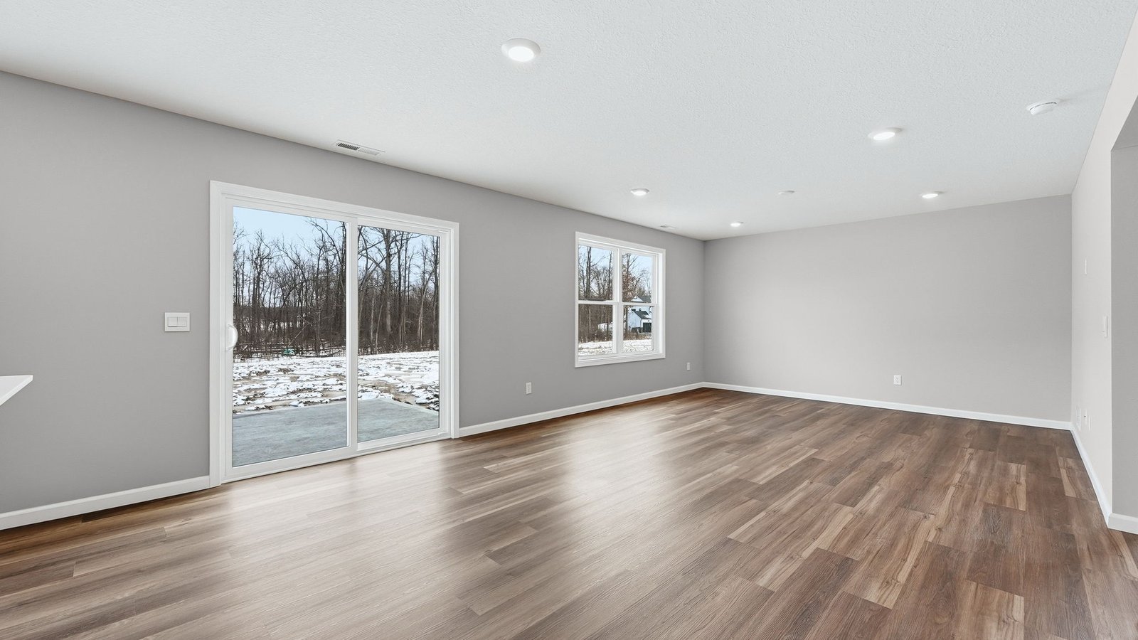 open concept casual dining space with lvp flooring and sliding door to backyard