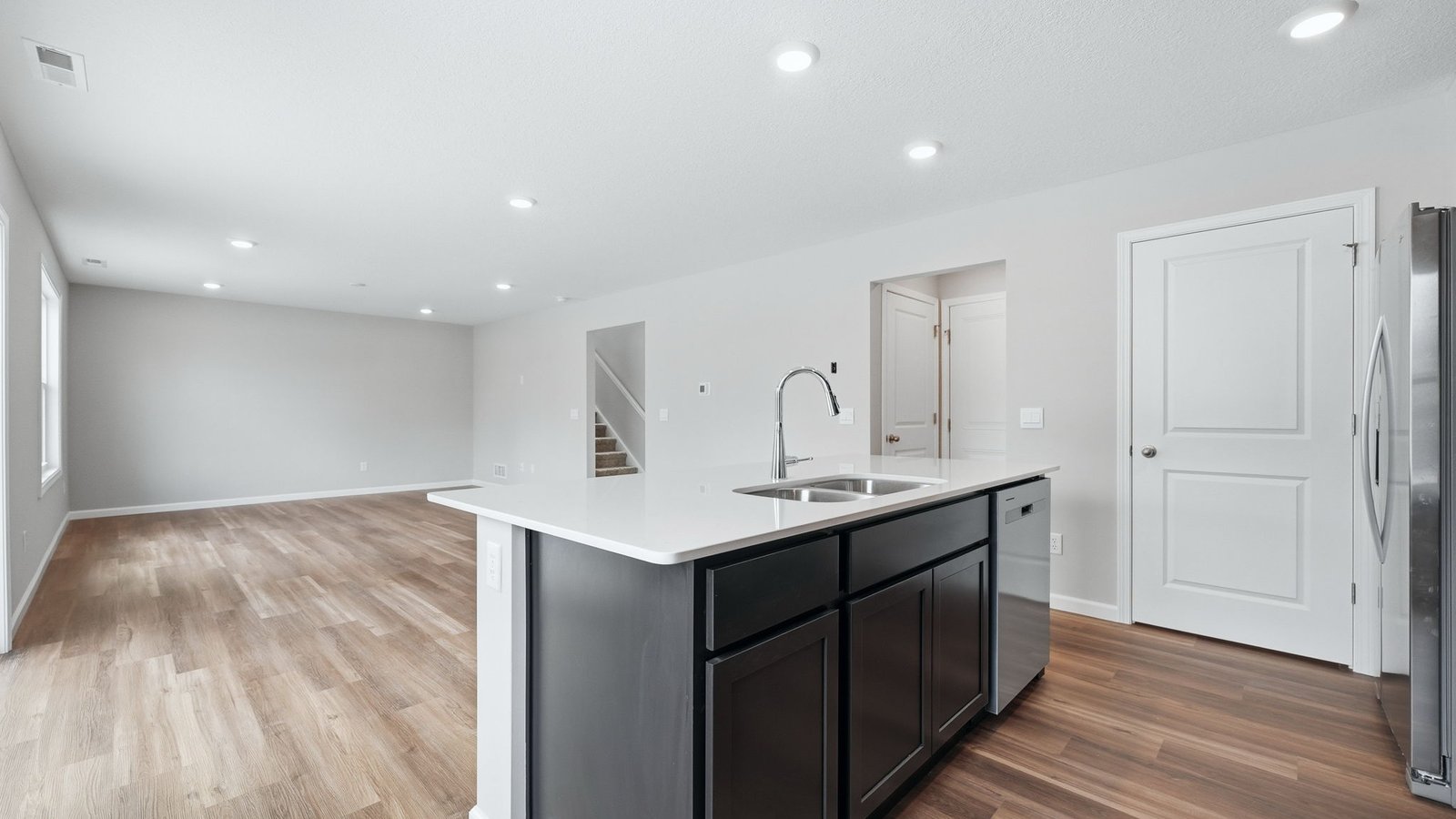 n the kitchen, you’ll find a large center island with bar seating, sleek quartz countertops, sarsaparilla shaker style cabinets, ceramic tile backsplash, and a walk-in pantry with the Freedom Rail system for extra storage.