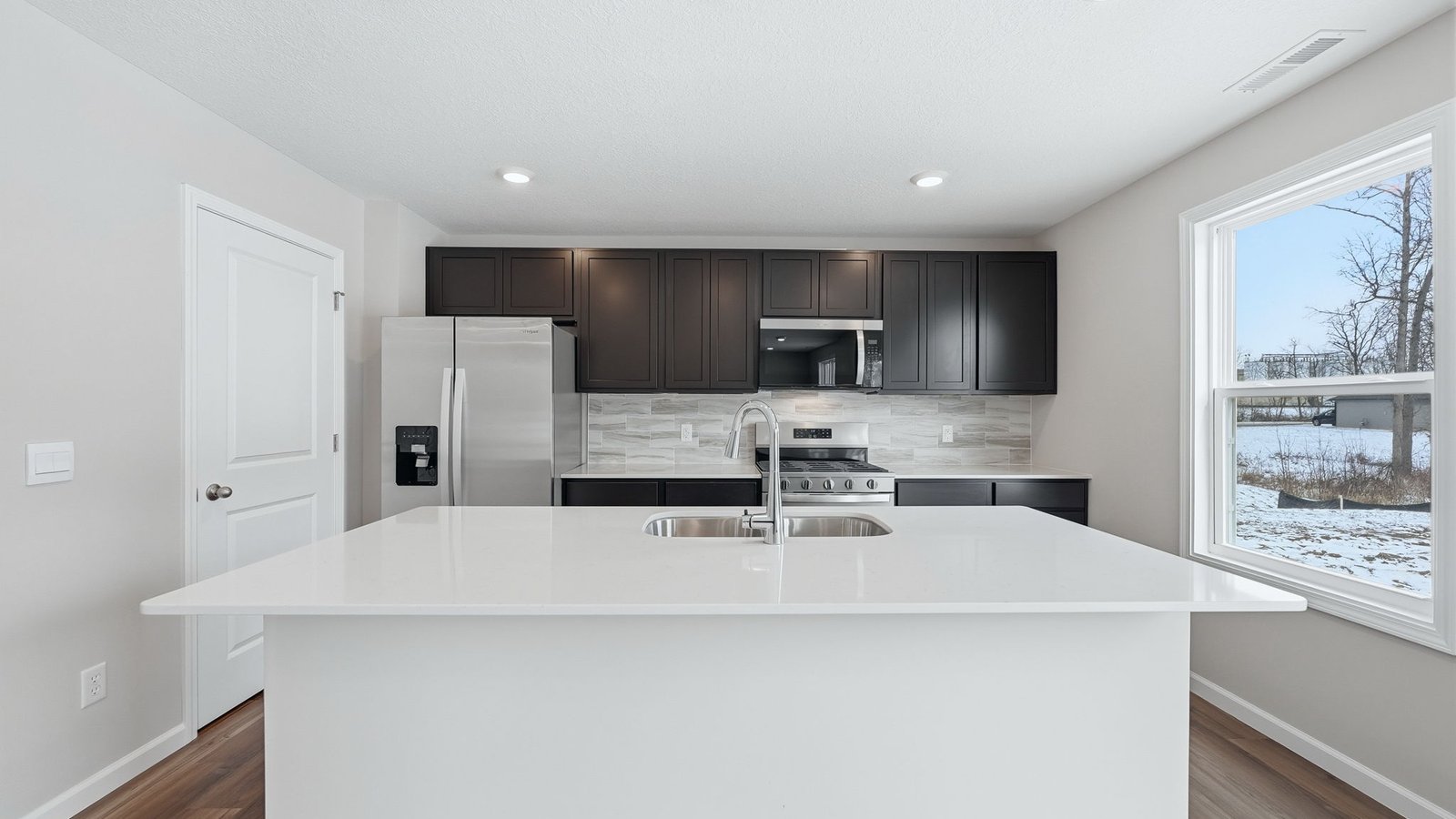 n the kitchen, you’ll find a large center island with bar seating, sleek quartz countertops, sarsaparilla shaker style cabinets, ceramic tile backsplash, and a walk-in pantry with the Freedom Rail system for extra storage.