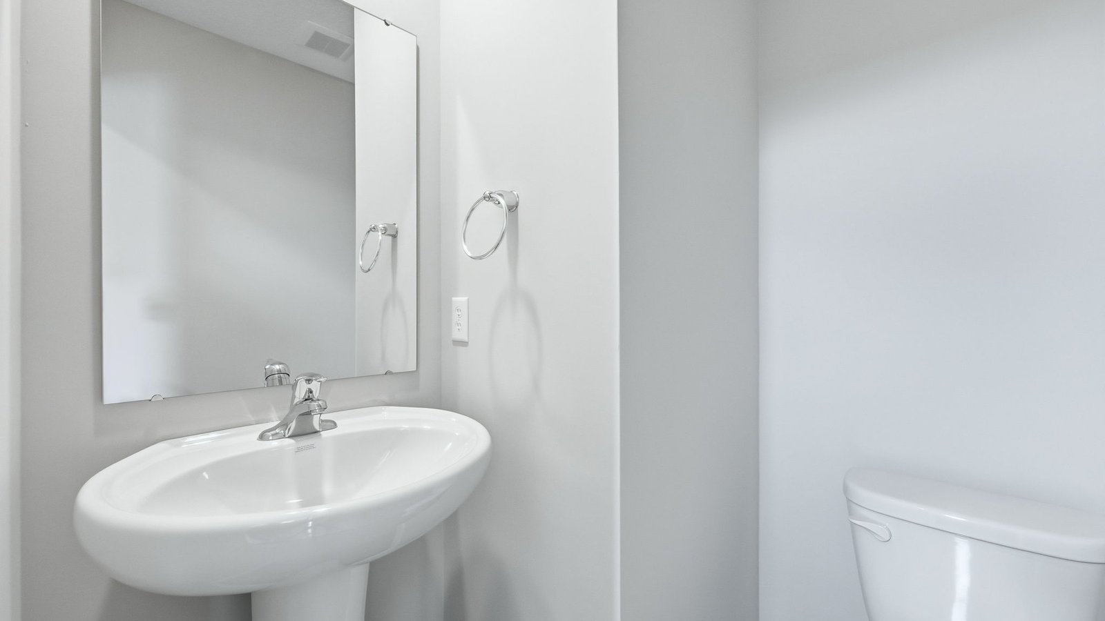 first floor powder bathroom with toilet and pedestal sink