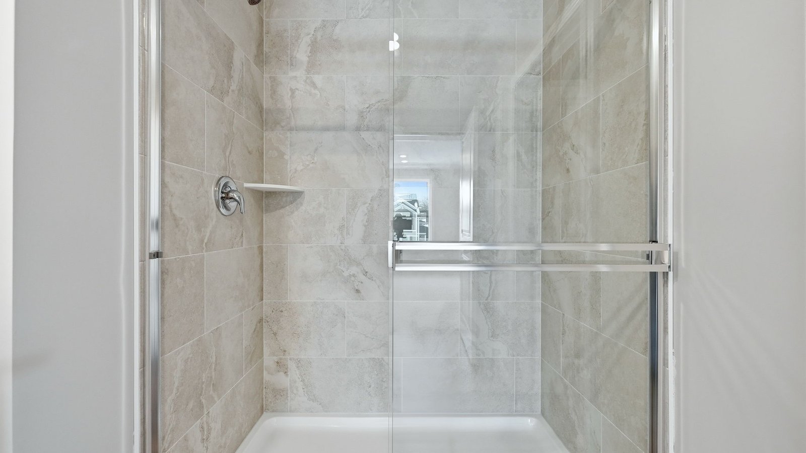 primary ensuite bathroom with dual sinks, walk-in ceramic tile shower, and lvp flooring
