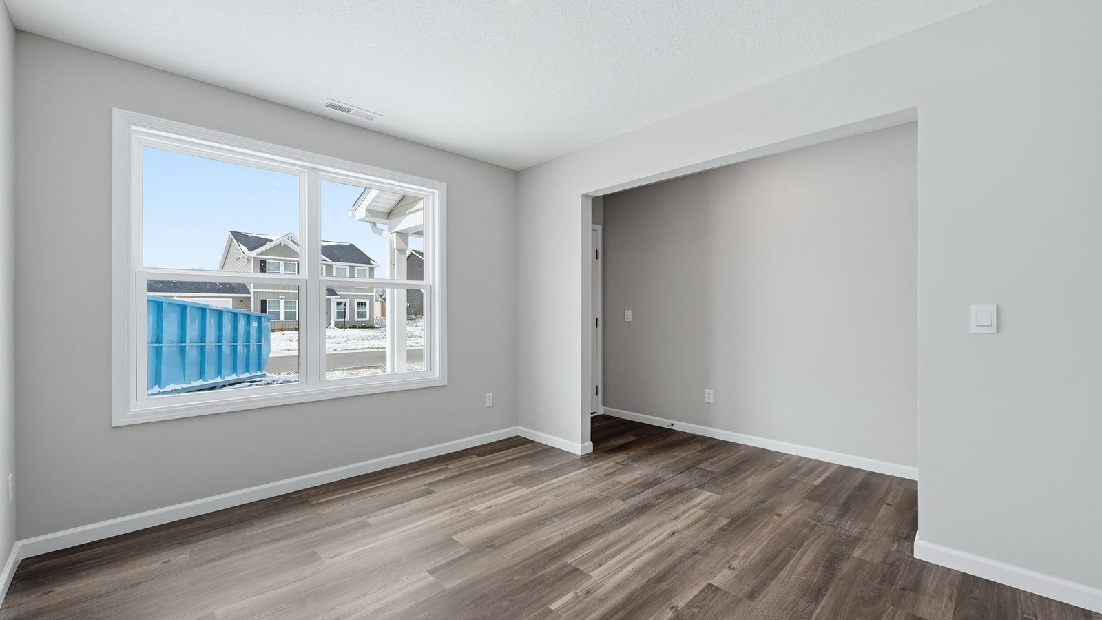 first floor front of home study with lvp flooring, popular grey walls, and 2 windows