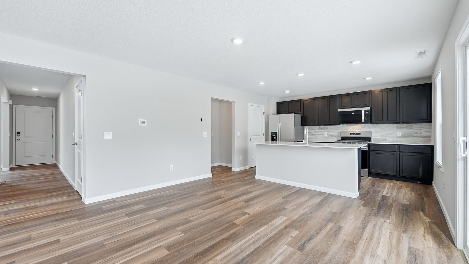 open concept casual dining space with lvp flooring and sliding door to backyard