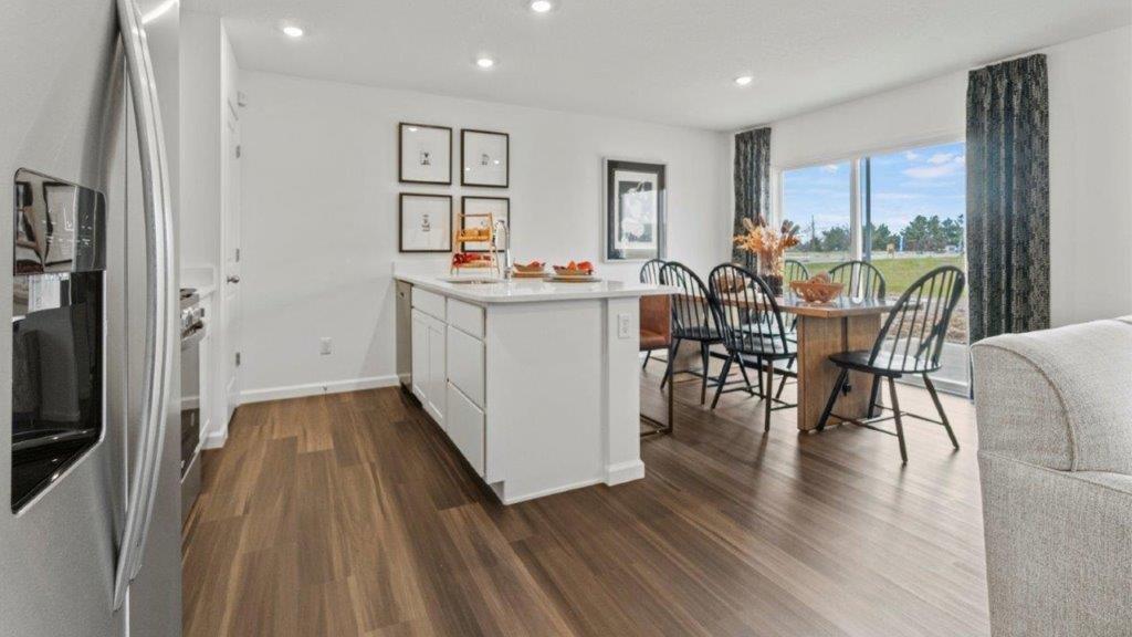 aldridge kitchen with white cabinets, stainless steel appliances, island with seating with quartz counters